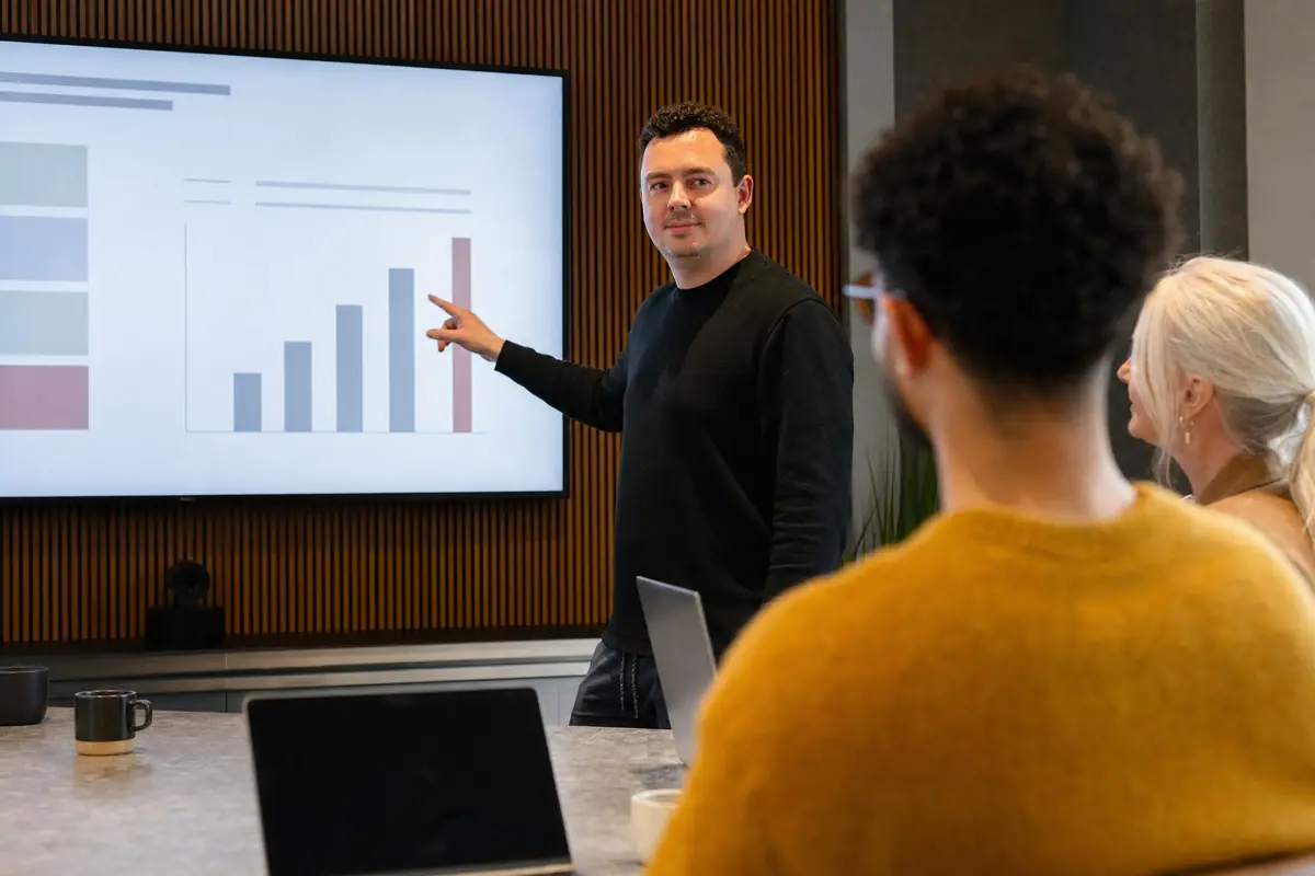 Tom presenteert campagneresultaten op een groot scherm